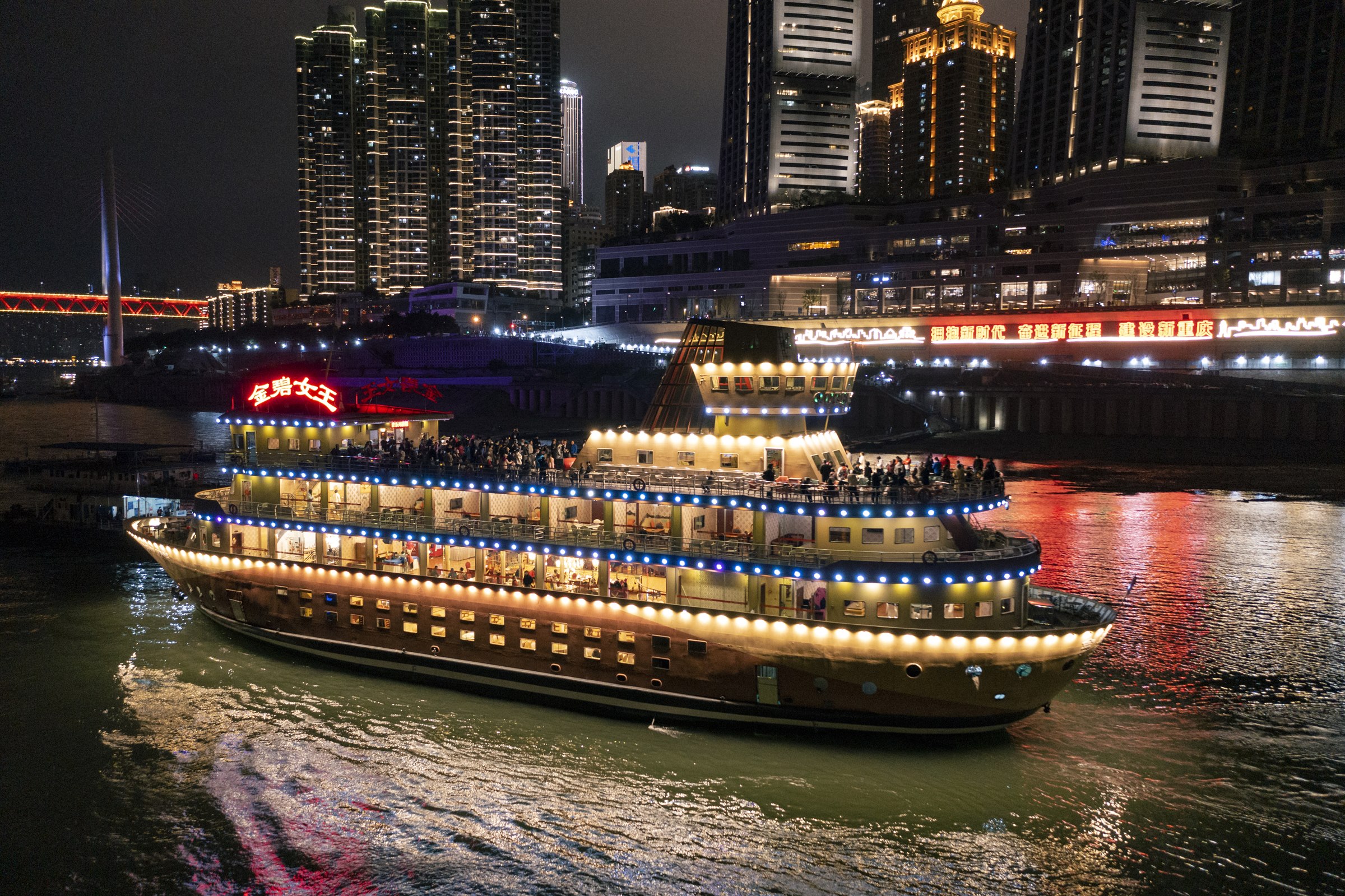 A night cruise boat passes Chongqing's illuminated riverfront