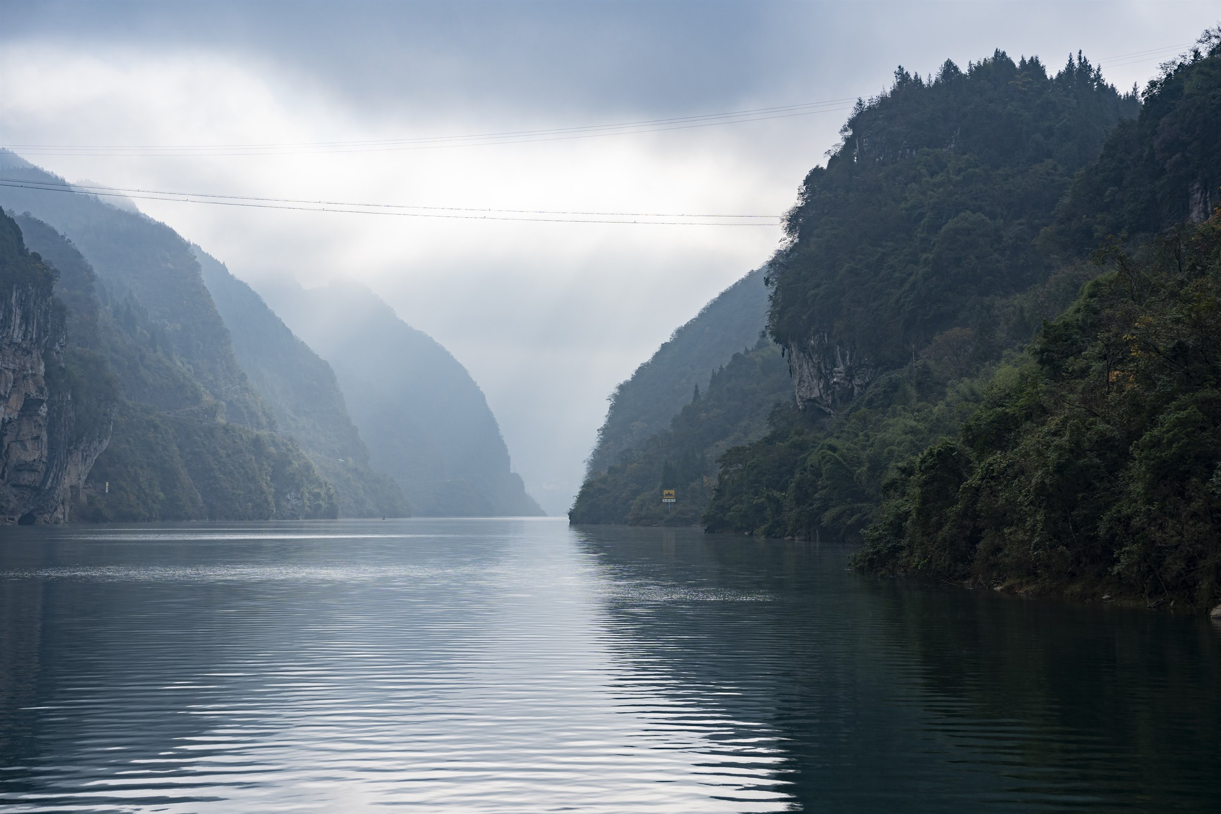 Misty mountain slopes rising above the Wujiang River